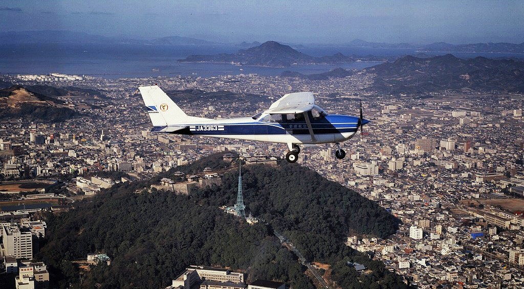 cessna-flying-over-a-city