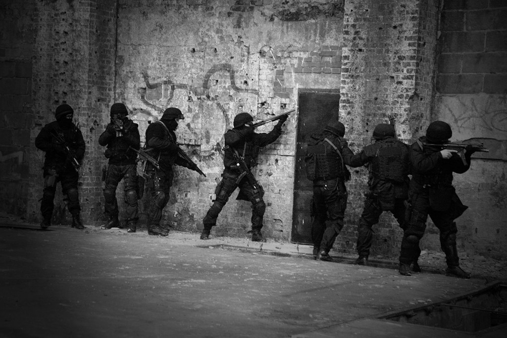 Subdivision anti-terrorist police during a black tactical exercises. Entry to the premises. Real situation. Black and white photo with film grain.