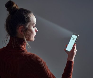 Female scans face using facial recognition system on smartphone for biometric identification. Future high tech technology and face id
