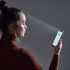 Female scans face using facial recognition system on smartphone for biometric identification. Future high tech technology and face id