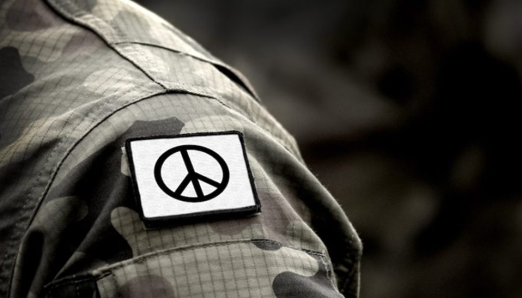 Peace sign on military uniform. The Peace symbol. Peace and war.