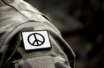 Peace sign on military uniform. The Peace symbol. Peace and war.