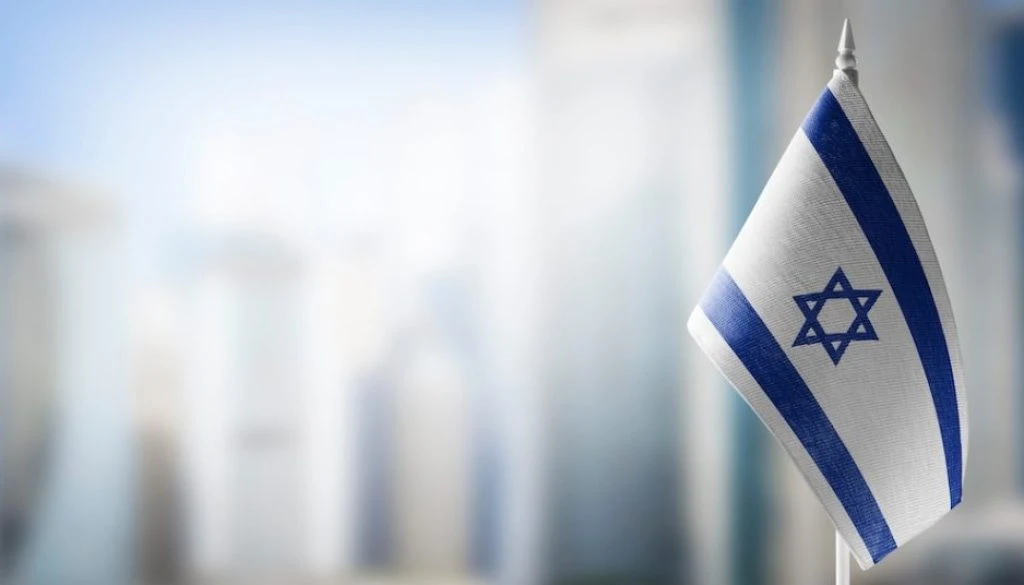 A small flag of Israel on the background of a blurred background