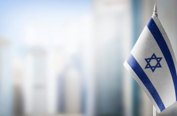 A small flag of Israel on the background of a blurred background