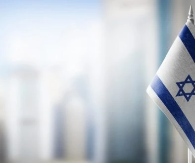 A small flag of Israel on the background of a blurred background