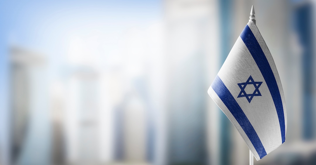 A small flag of Israel on the background of a blurred background