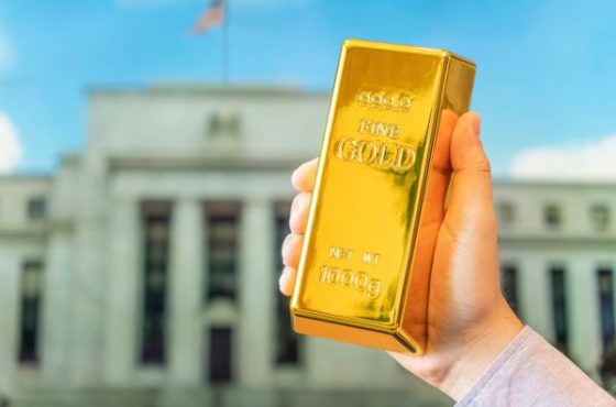 A,Gold,Bar,In,A,Man's,Hand,Against,The,Background A,Gold,Bar,In,A,Man's,Hand,Against,The,Background