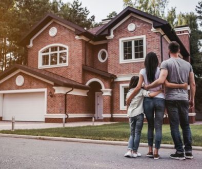 Back,View,Of,Happy,Family,Is,Standing,Near,Their,Modern