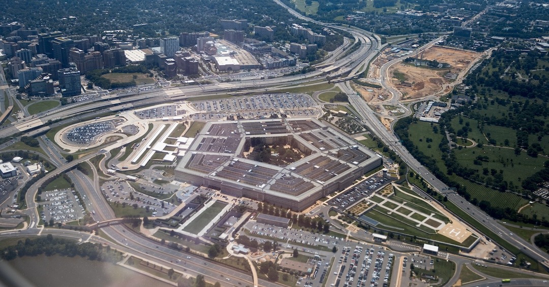 Aerial view of the Pentagon complex with surrounding roads, parking and greenery. g