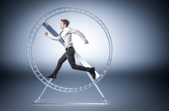young businessman run in huge hamster wheele