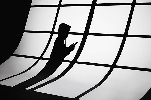 Shadow of man. Scammer. Phone fraud Shadow of man. Scammer. Phone fraud