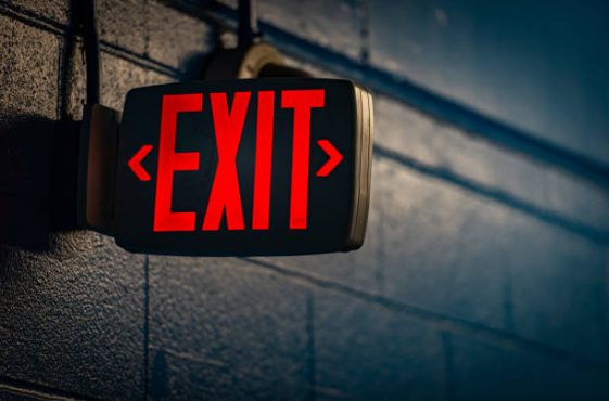 glowing exit sign by night on black wall