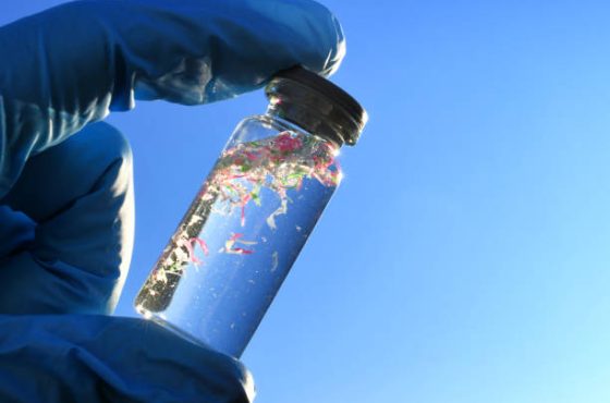 A glass vial containing water and micro plastic pieces of pollution