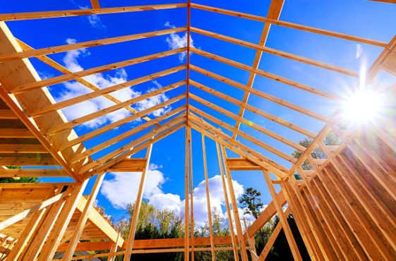 Workers construct building frame with wooden beams roof frame trusses